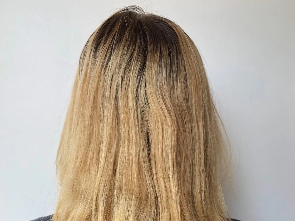 Before: the back of a client’s head, brassy yellow blonde with dark roots grown out