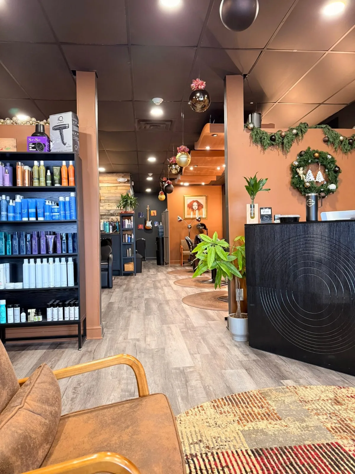 From the lounge: shelves of hair products, the front desk and the styling chairs, with the shampoo sinks at the back